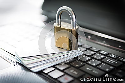 Padlock and credit cards on top of laptop
