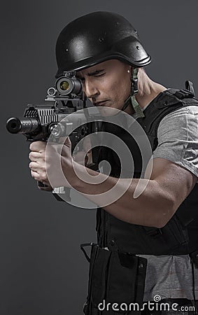 Paintball sport player wearing protective helmet aiming pistol ,