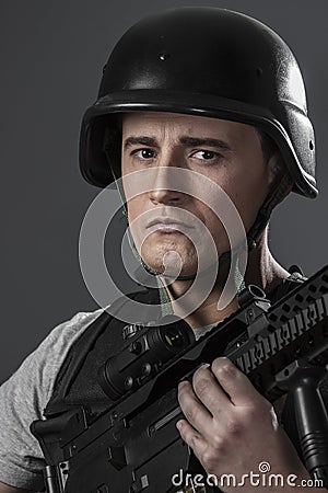Paintball sport player wearing protective helmet aiming pistol ,