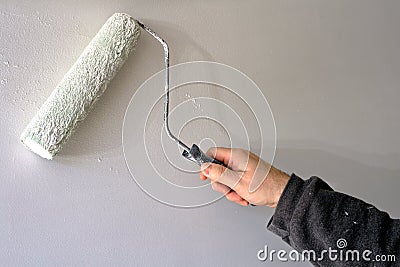 Painter Painting a House Wall with a Paint Roller
