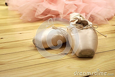 Pair of ballet shoes pointes on wooden floor