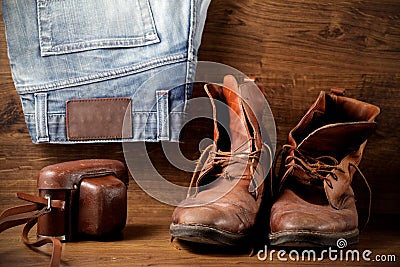 A pair of boots, jeans and old camera