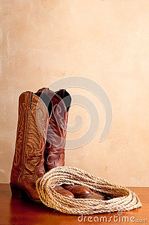 A pair of brown cowboy boots and rope