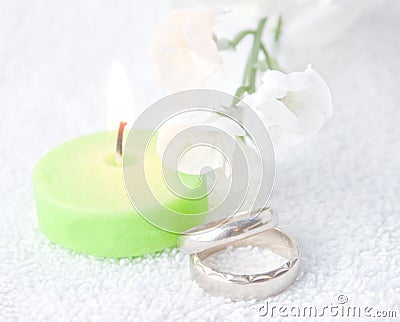 Pair Of Wedding Rings With Lit Green Candle