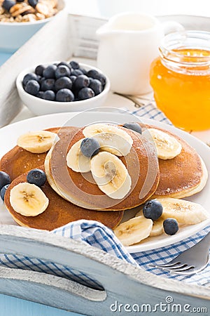 Pancakes with banana, honey and blueberries for breakfast