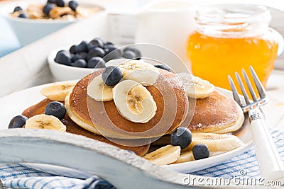 Pancakes with banana, honey and fresh blueberries for breakfast