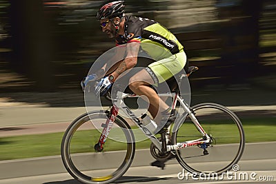 Panning of a cyclist riding bicycle in a sunny day, competing for Road Grand Prix event, a high-speed circuit race in Ploiresti-Ro
