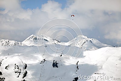 Paragliding above snow covered mountains