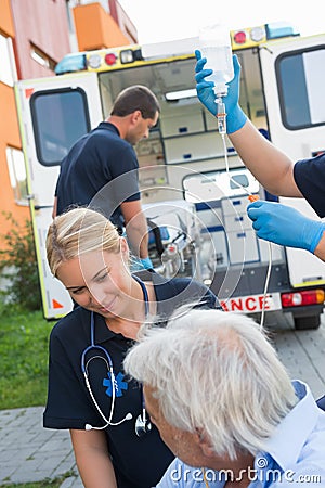 Paramedical team helping injured patient on street