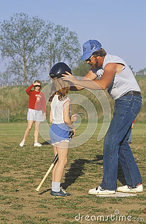 Parent coaching Girls baseball game