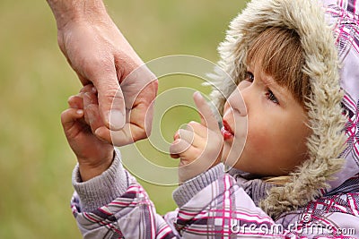 Parent holds the hand of a  child