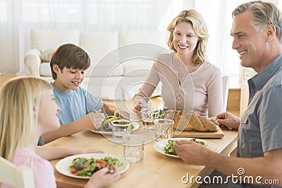 Parents And Children Having Food Together At Dining Table