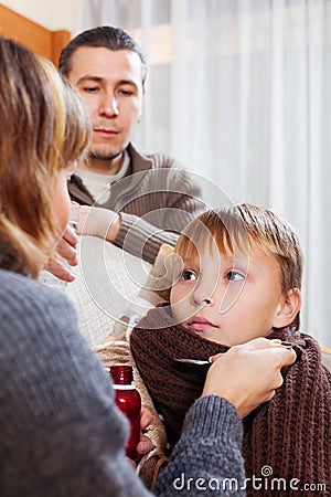 Parents giving medicinal sirup to teenager