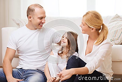 Parents and little girl sitting on floor at home