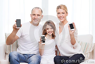 Parents and little girl with smartphones at home