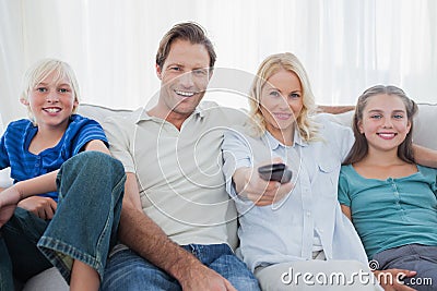 Parents posing with children and watching television