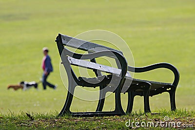 Park bench and dog walker