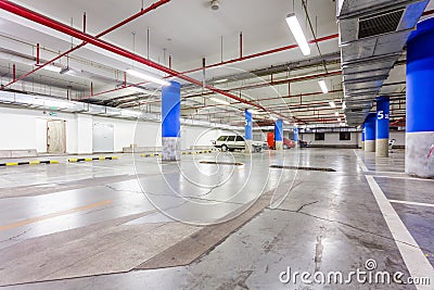 Parking garage, underground interior with a few parked cars