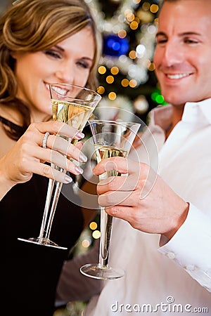 Party: Couple Toasting With Champagne By Christmas Tree