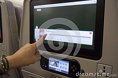 Passenger using entertainment screen in plane