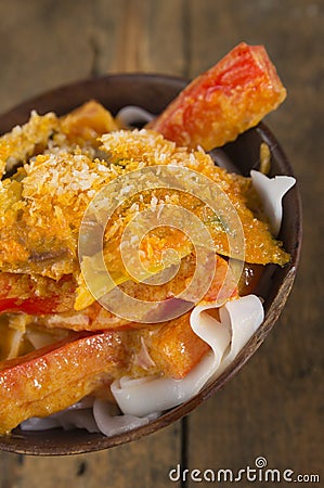 Pasta with peppers and chicken in wooden bowl
