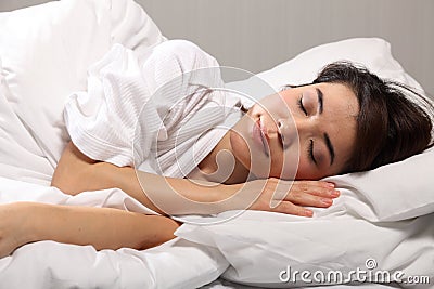Peaceful beautiful oriental girl sleeping in bed