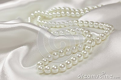 Pearl necklace on a satin or silk background