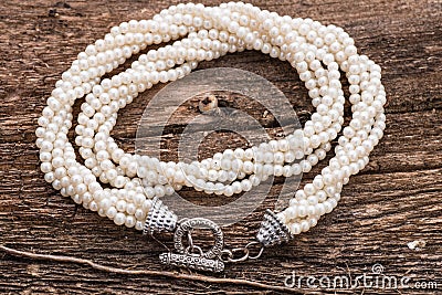 Pearl necklace on wood background