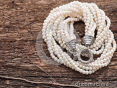 Pearl necklace on wood background