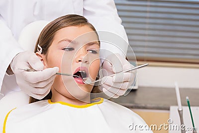 Pediatric dentist examining a patients teeth in the dentists chair