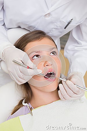 Pediatric dentist examining a patients teeth in the dentists chair