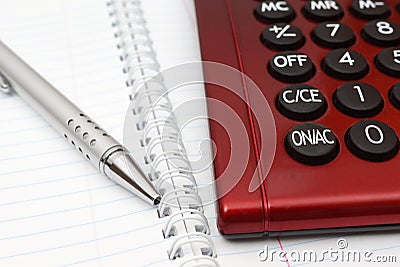 Pen, calculator and notebook close up