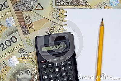 Pencil and calculator on polish money banknotes
