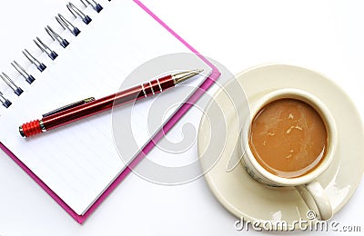 Pencil on a white spiral squared notebook with cup of coffee