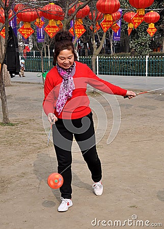 Pengzhou, China: Woman Spinning Ti Huang Top