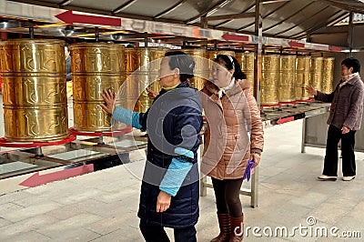 Pengzhou, China: Women Spinning Tibetan Prayer Wheel Drums