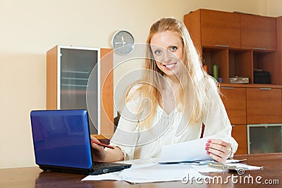 Pensive blonde woman working with financial documents