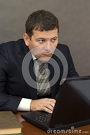 Pensive face businessman sitting at computer