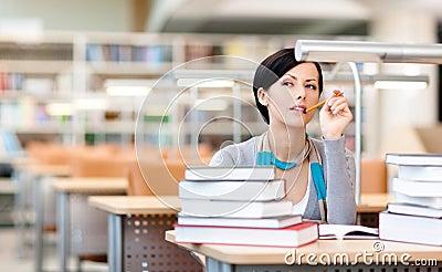 Pensive female student studies at the reading hall