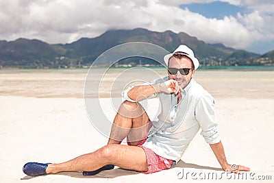 Pensive young man sitting on the beach