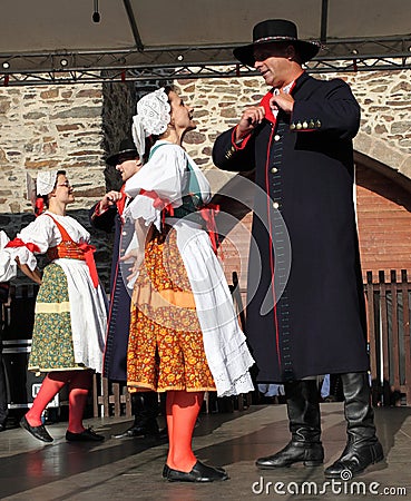 People dressed in Czech traditional garb dancing and singing.