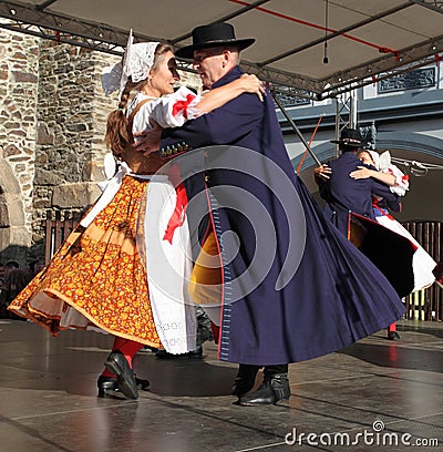 People dressed in Czech traditional garb dancing and singing.