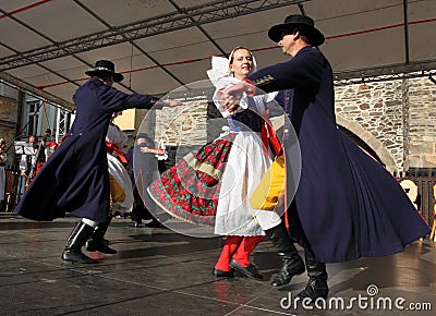 People dressed in Czech traditional garb dancing and singing.