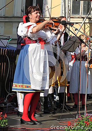 People dressed in Czech traditional garb dancing and singing.