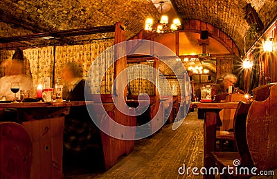 People drink inside the old bar with wooden tables