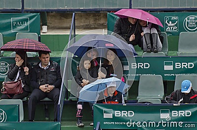 People in a grand stand with umbrellas