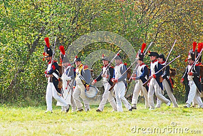 People in historical costumes march on the battle field.