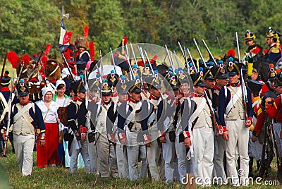 People in historical costumes march on the battle field.