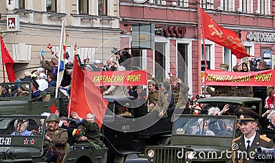 People in military uniform drive vintage cars