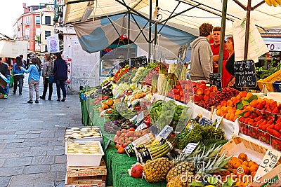 People near a counter with vegetables on a market in Venice, Ita